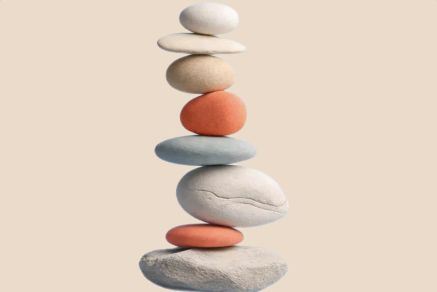 Stacked balance stones in coral and neutral tones representing wellbeing, emotional balance, and calm for therapy and mental wellbeing support